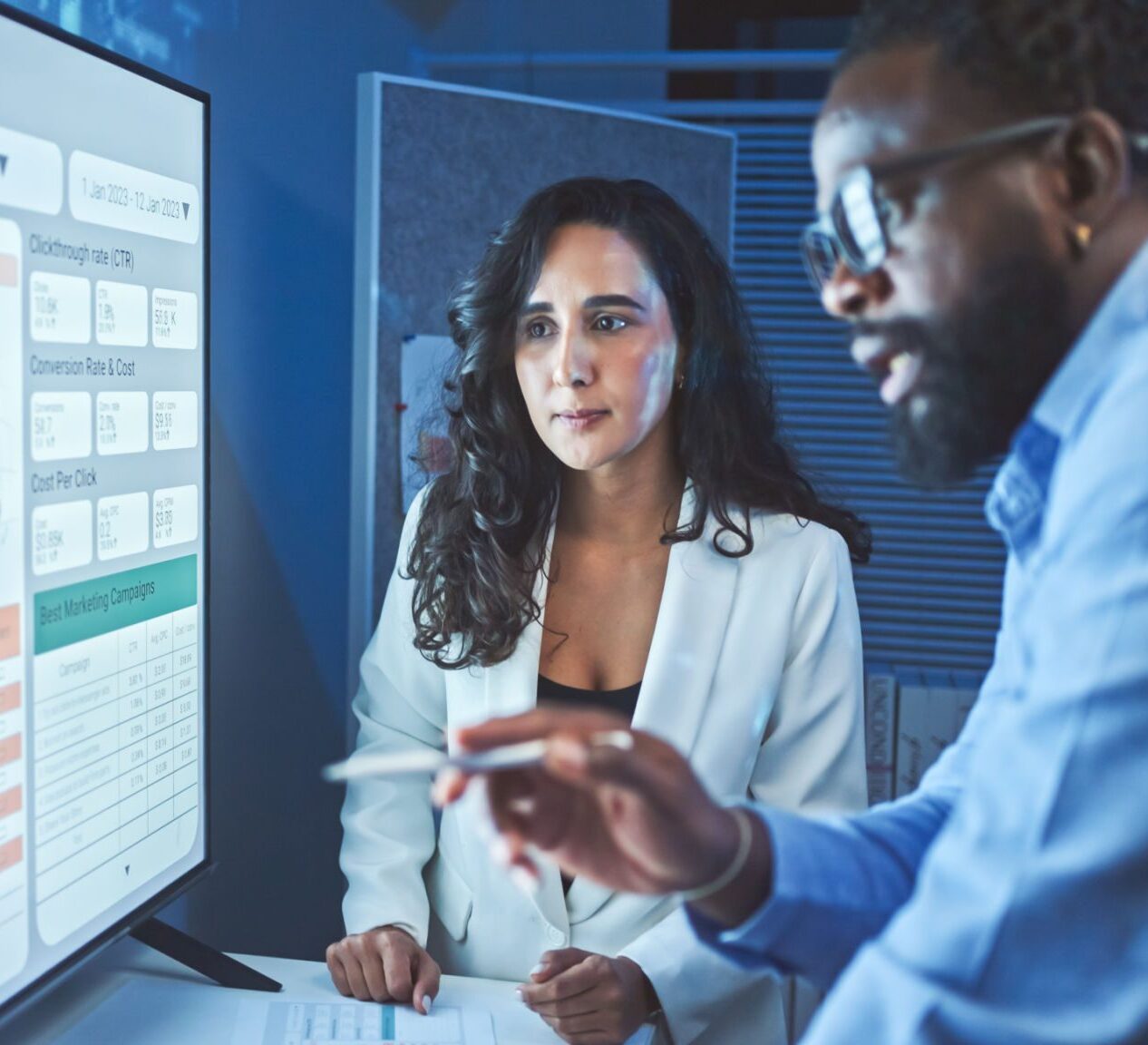 Two professionals analyzing data on screen.