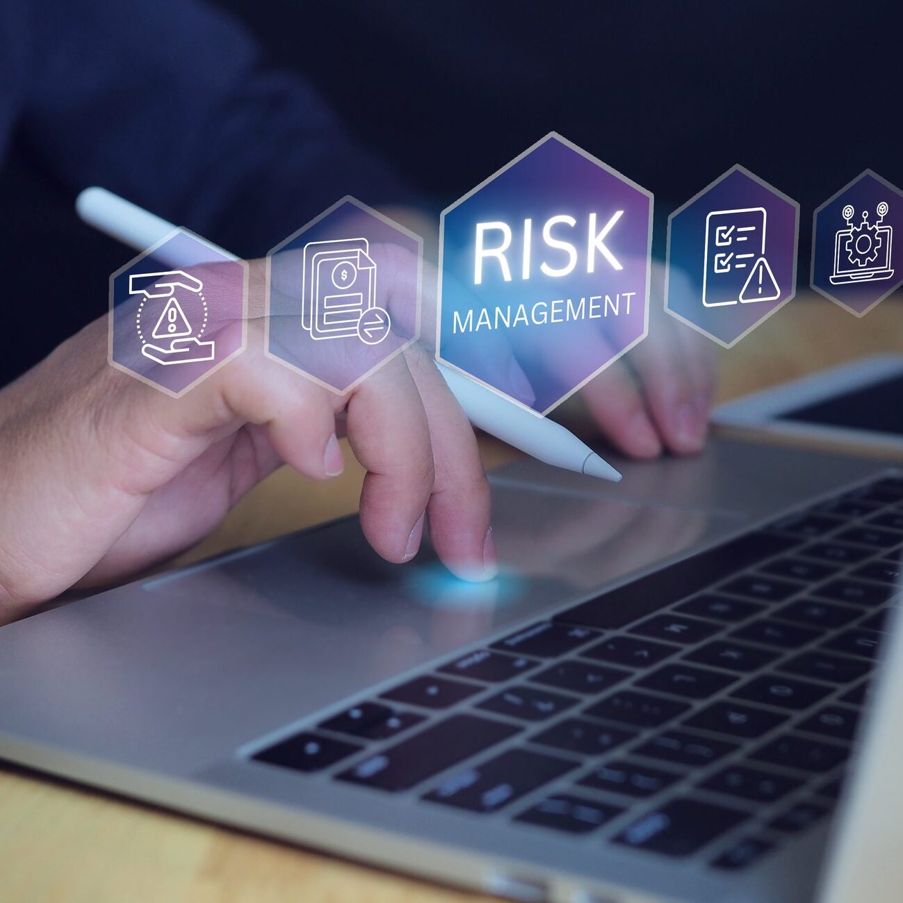Hand using laptop with risk management icons.